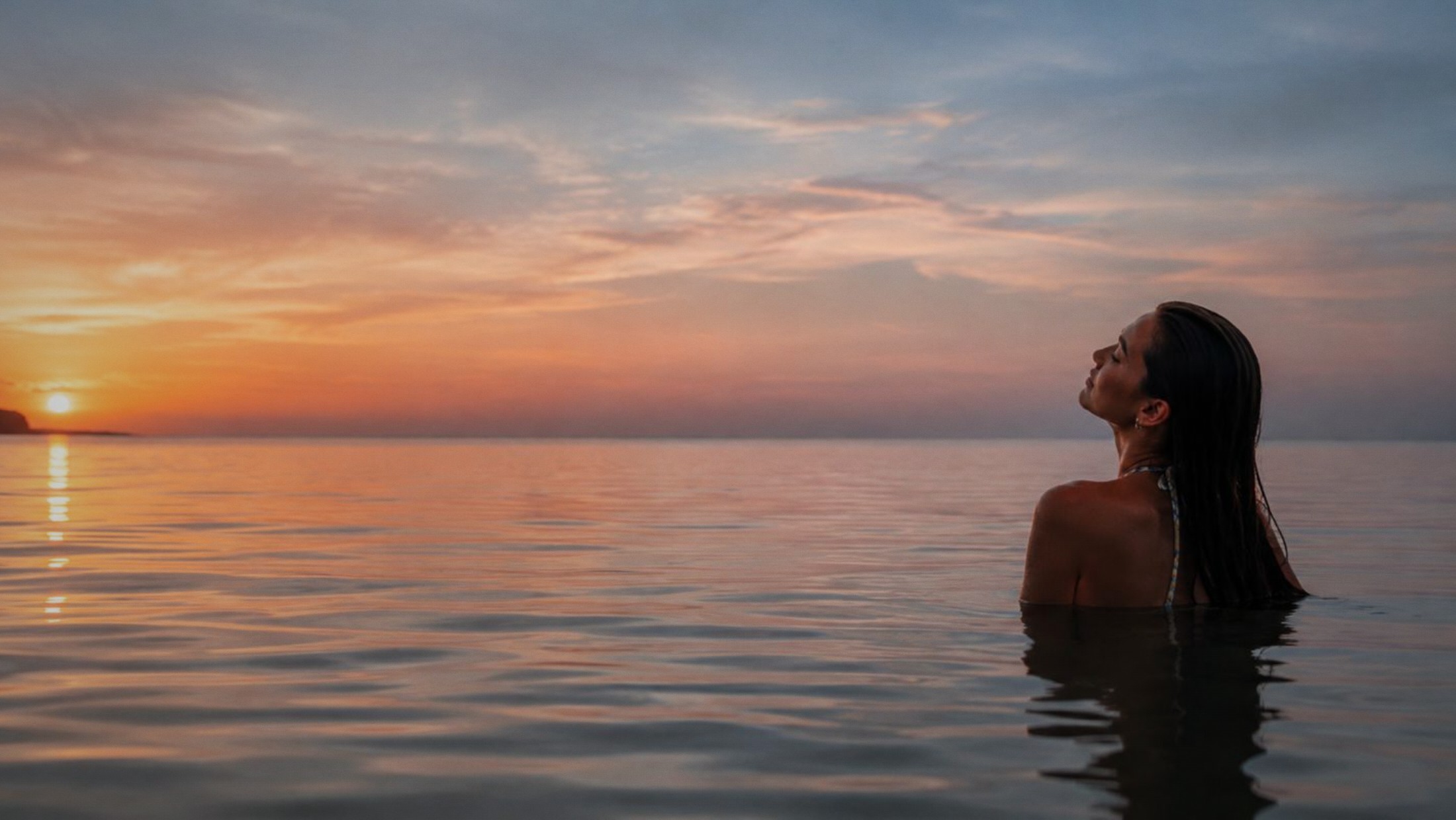 Mujer en el mar al atardecer
